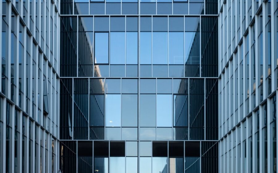 Contemporary building facade with reflective glass windows in an urban environment.