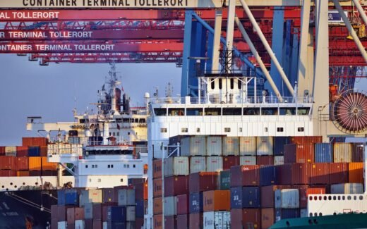 Container ships docked at Tollerort Terminal, Hamburg during sunset.