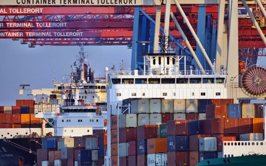 Container ships docked at Tollerort Terminal, Hamburg during sunset.